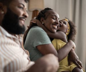 Cute girl embracing mother at home